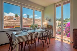 comedor con mesa, sillas y ventanas en La Bouganville, en Santa Margherita Ligure