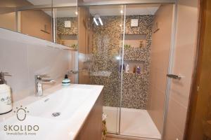 a bathroom with a shower with a white sink and a glass shower stall at Ferienwohnung Chalet Tamalone, Mörel in Breiten +8 photos