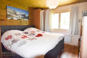 sypialnia z łóżkiem w pokoju z górami w obiekcie Ferienwohnung Chalet Tamalone, Mörel w mieście Breiten