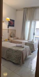 a hotel room with a bed and two lamps at Hostal Alhambra Tarragona in Tarragona