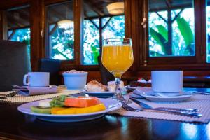 a table with a plate of food and a glass of orange juice at Selva de Laurel in Puerto Iguazú