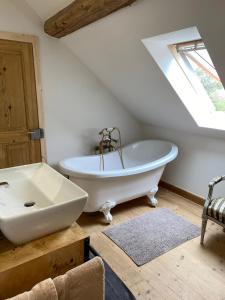 un bagno con una vasca bianca e un lavandino di Ferme du Val de Bruinen a Sainte-Marie-aux-Mines