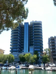 un gran edificio azul con barcos en un puerto deportivo en Appartamento Tiziano, en Grado