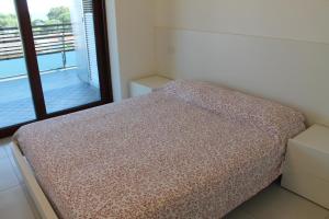 Cama pequeña en habitación con ventana en Appartamento Tiziano, en Grado