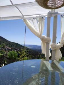 uma mesa de vidro com vista para uma montanha em A Casa VillaRadriimas em Sollacaro