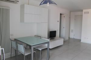 comedor con mesa, sillas y TV en Appartamento Tiziano, en Grado