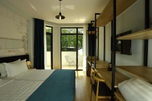 a bedroom with a bed and a desk and a bed and a balcony at Graphica Black Sea in Shekhvetili +56 photos