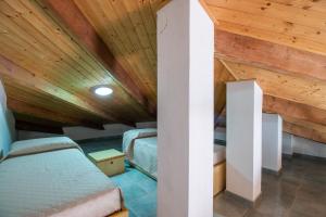 a room with two beds and a wooden ceiling at Reparata in Capo Testa