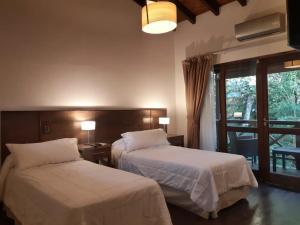 um quarto de hotel com duas camas e uma janela em Selva de Laurel em Puerto Iguazú