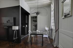 a dining room with a table and a chandelier at LE CELESTIA - Centre Historique - in Rennes