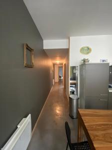 a kitchen with a table and a refrigerator at APPARTEMENT neuf au centre ville situé au rdc avec terrasse in Givet