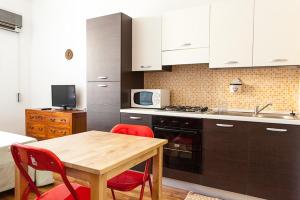 cocina con mesa de madera y sillas rojas en S Efisio in Cagliari Centre Q4825, en Cagliari
