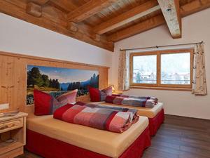 2 Betten in einem Zimmer mit einem großen Fenster in der Unterkunft Appartement Alpenzauber in Längenfeld