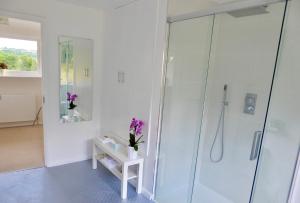 a bathroom with a glass shower with purple flowers at Ranmore Rise Retreat in the Surrey Hills in Dorking +39 photos