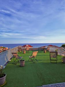eine Terrasse mit Stühlen und das Meer im Hintergrund in der Unterkunft Residence Laura in Bordighera
