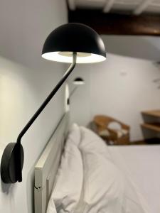 una lámpara negra sentada sobre una cama en A Parada House by Kev, en Parada del Sil