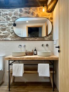 Baño con 2 lavabos y espejo en A Parada House by Kev, en Parada del Sil