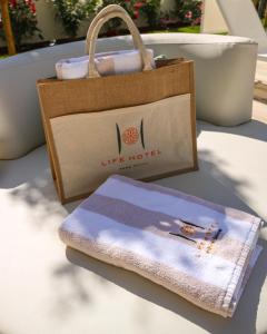 a tote bag and a towel on a table at Life Hotel in Bibione