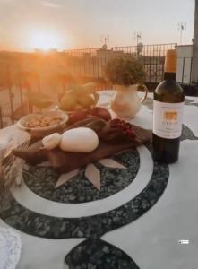 uma mesa coberta com comida e uma garrafa de vinho em Palazzo Laureano - Dimora Storica em Tricarico