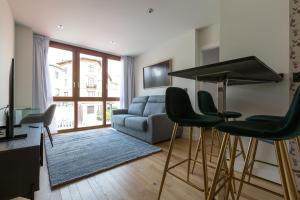 sala de estar con sofá, mesa y sillas en APARTAMENTOS NIZA, en Santander