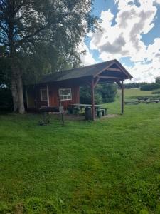 a picnic shelter with a picnic table in a field at Kõljala puhkeküla in Kaali