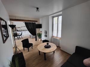 een woonkamer met een tafel en stoelen en een woonkamer bij L'OASIS - Maison rénovée à 10 min de Beauval in Saint-Romain-sur-Cher