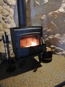a stove with a fire inside of it at Maunder Cottage in Aldinga