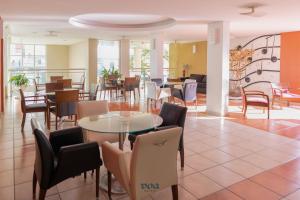 アグアス・デ・リンドイアにあるVOA Plazza Hotelの食堂のテーブルと椅子付きレストラン