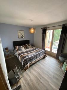 a bedroom with a bed and a large window at Chaleureux appartement T4 cosy, Font Romeu Odeillo Via in Font-Romeu-Odeillo-Via