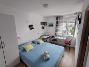 een slaapkamer met een blauw bed met een knuffeldier erop bij Apartments Cappuccino in Podstrana