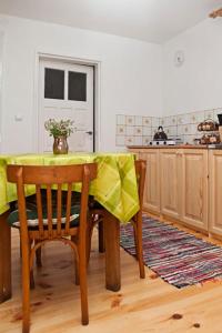 a kitchen with a table with a yellow table cloth at Chatka na Roztoczu in Bondyrz +37 photos