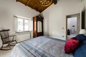 a bedroom with a large bed and a chair at Gli specchi in Lucca
