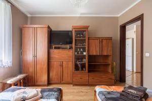 Apartament Grażyna في غيجيتسكو: غرفة معيشة مع تلفزيون وخزانة خشبية