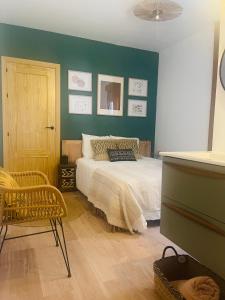 ein Schlafzimmer mit einem Bett und einer grünen Wand in der Unterkunft Casa del palmar junior in Valencia
