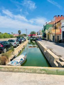 Casa del palmar junior في فالنسيا: قارب صغير في قناة بجوار موقف للسيارات