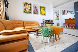 uma sala de estar com um sofá, uma mesa e cadeiras em Super OYO 91350 Garden Hostel em Bandung