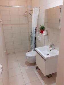 a white bathroom with a toilet and a sink at Epicentar in Sarajevo
