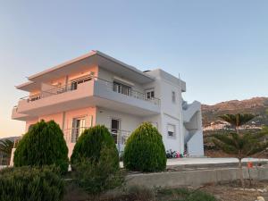 a white house with trees in front of it at 360° View Suites Tan in Neapoli Voion