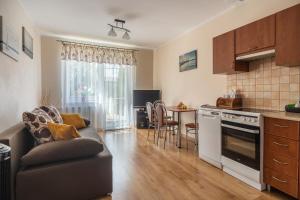 a kitchen and living room with a couch and a table at Apartament Grażyna in Giżycko