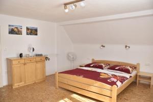 um quarto com uma cama de madeira e uma cómoda de madeira em Chalupa Abecha em Dolní Poustevna