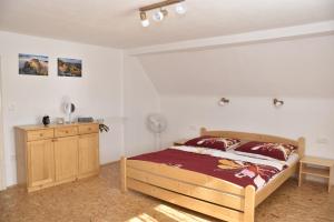 a bedroom with a wooden bed and a wooden dresser at Chalupa Abecha in Dolní Poustevna