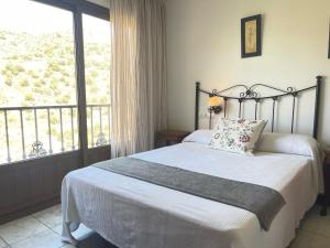 um quarto com uma cama e uma grande janela em Hotel Al-Andalus em Torrox
