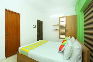 1 dormitorio con 1 cama grande y almohadas coloridas en The Solo Apartments Kadavanthra, en Ernakulam