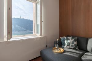 een woonkamer met een bank en een raam bij Panorama Luxury Dream Home in The Center in Boedapest