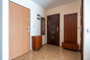 a hallway with two wooden doors and a room at Apartament Grażyna in Giżycko
