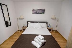 a bedroom with a bed with towels on it at Casa Maria in Constanţa