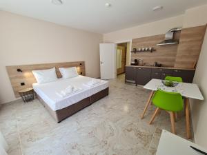 a bedroom with a bed and a table and a kitchen at Aparthotel Happy in Primorsko