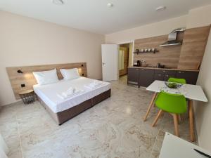 a bedroom with a bed and a table and a kitchen at Aparthotel Happy in Primorsko +56 photos