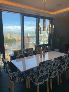 a dining room with a table and chairs and a large window at Parliament House - Luxury Penthouse in London
