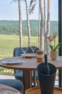 a wooden table with two glasses and a bottle of wine at LOISIUM Wine & Spa Hotel Champagne in Mutigny